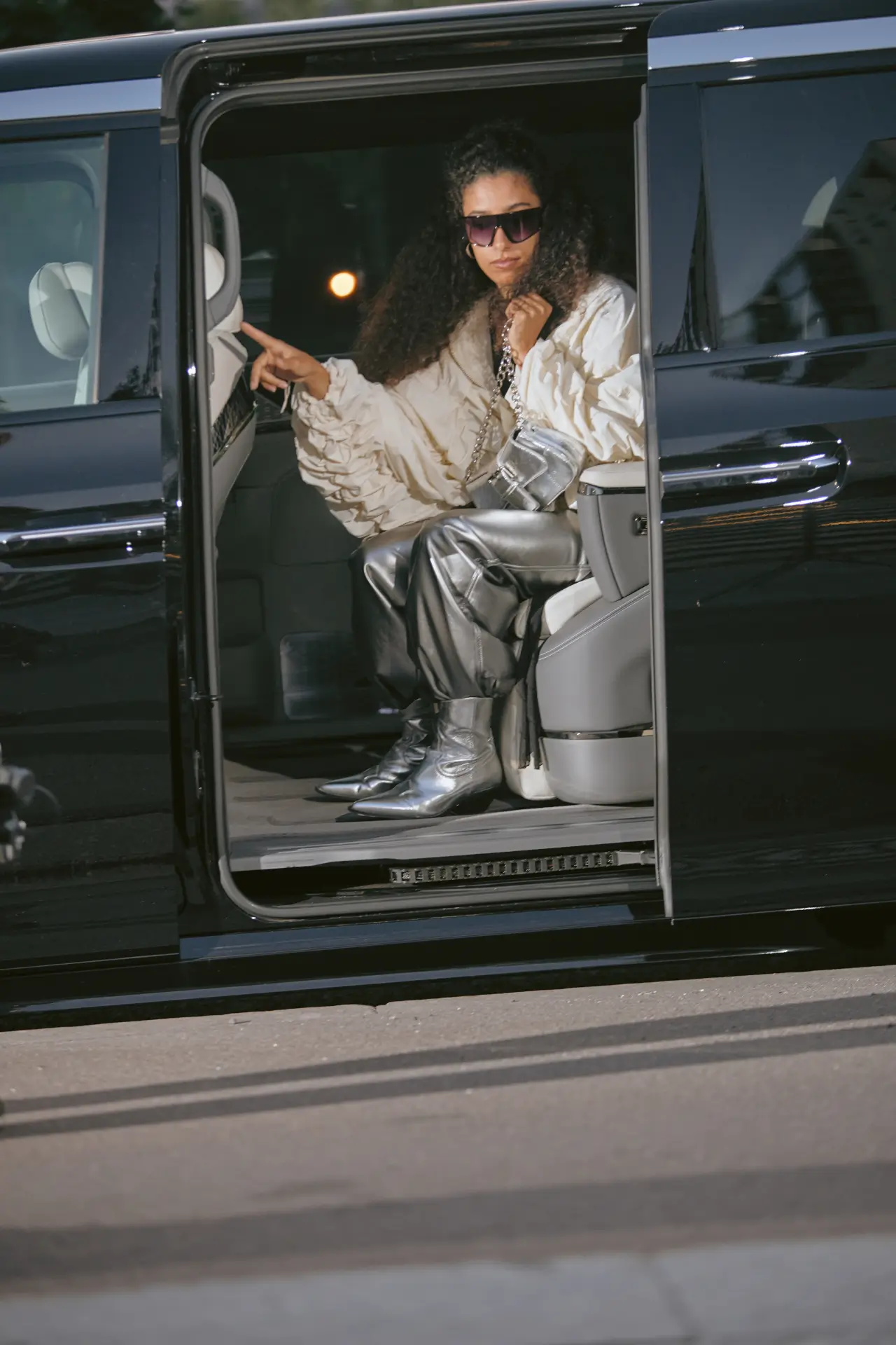 Person in stylish outfit exiting vehicle.